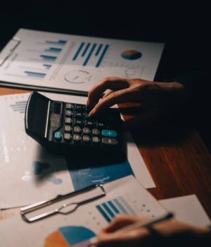 Close up businessman hand using calculator and working with laptop calculate about finance accounting at coffeeshop outdor, VAT Services